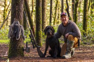 Hunter with tree squirrel hunting gear and his dog