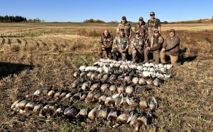 Hunters with geese and ducks