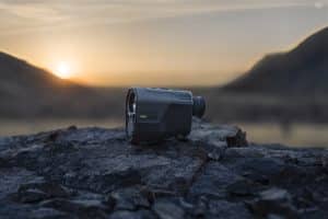 Garmin action camera resting on rugged rocks at sunset with a blurred mountain backdrop