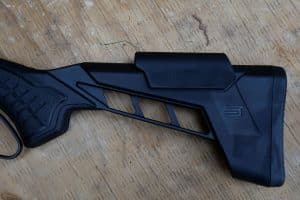 Close-up of the Savage Revel Tactical synthetic buttstock, showing the removable cheekpiece and rubber recoil pad.