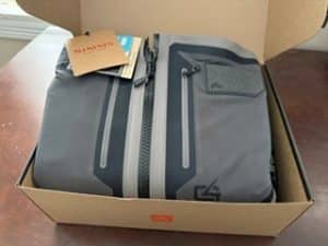 Simms G4Z zip-front fishing waders folded inside their original packaging.