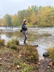 Stuart Wright fishing in Simms G4Z waders along a rocky river during fall.